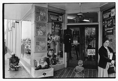 Woman, boy and man near entrance to store.