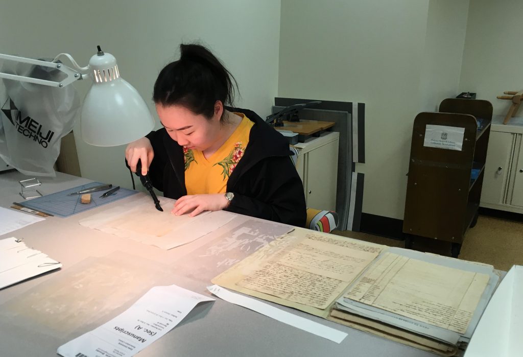 Helen Lee mends manuscript material ahead of digitization.