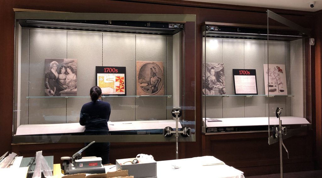 Open exhibit cases with reproduction images placed on shelves. 