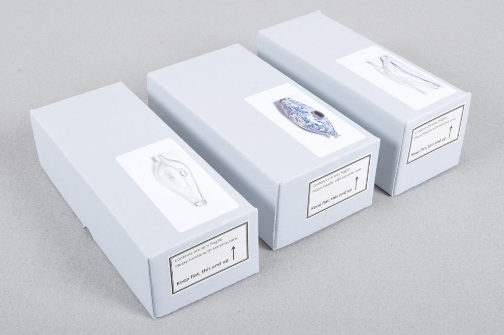 Archival boxes with picture labels of objects inside.