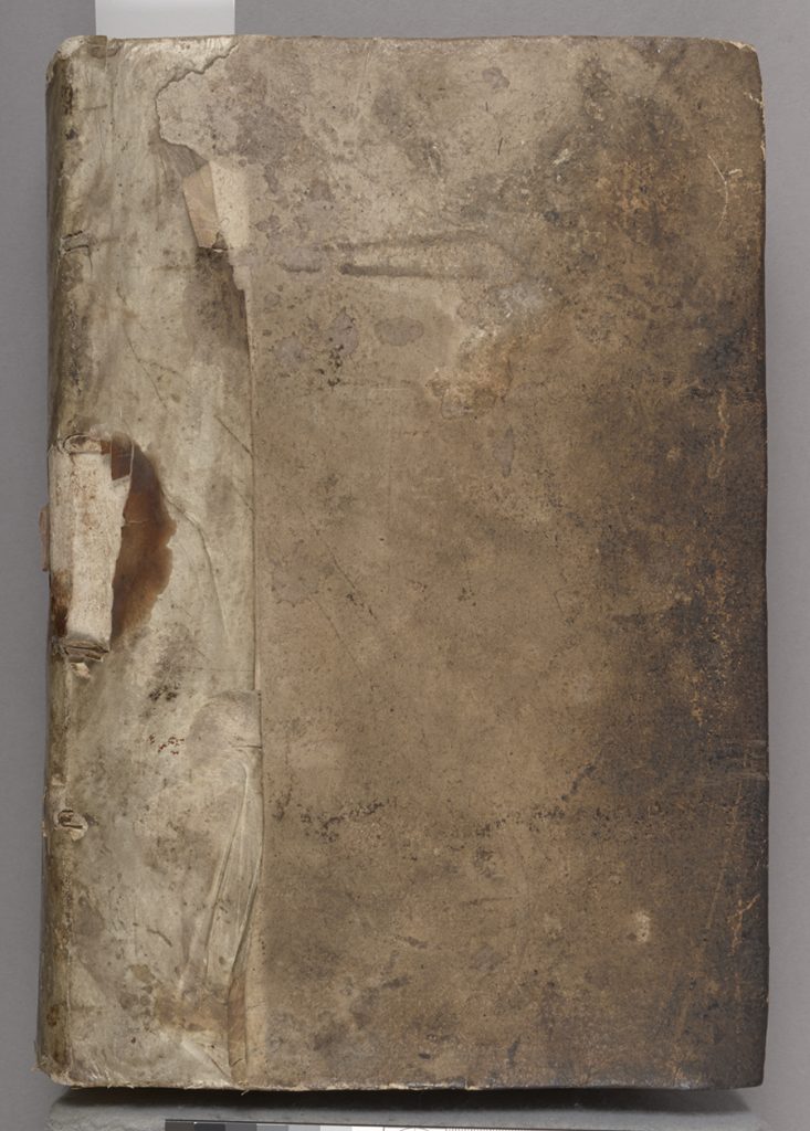 An image showing the front cover of the binding, with dark staining from handling on the fore-edge and damage to the parchment strip covering the spine. 