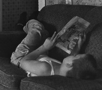Boy lying on couch, reading comics. From the William Gedney Photographs and Writings, 1950s-1989.