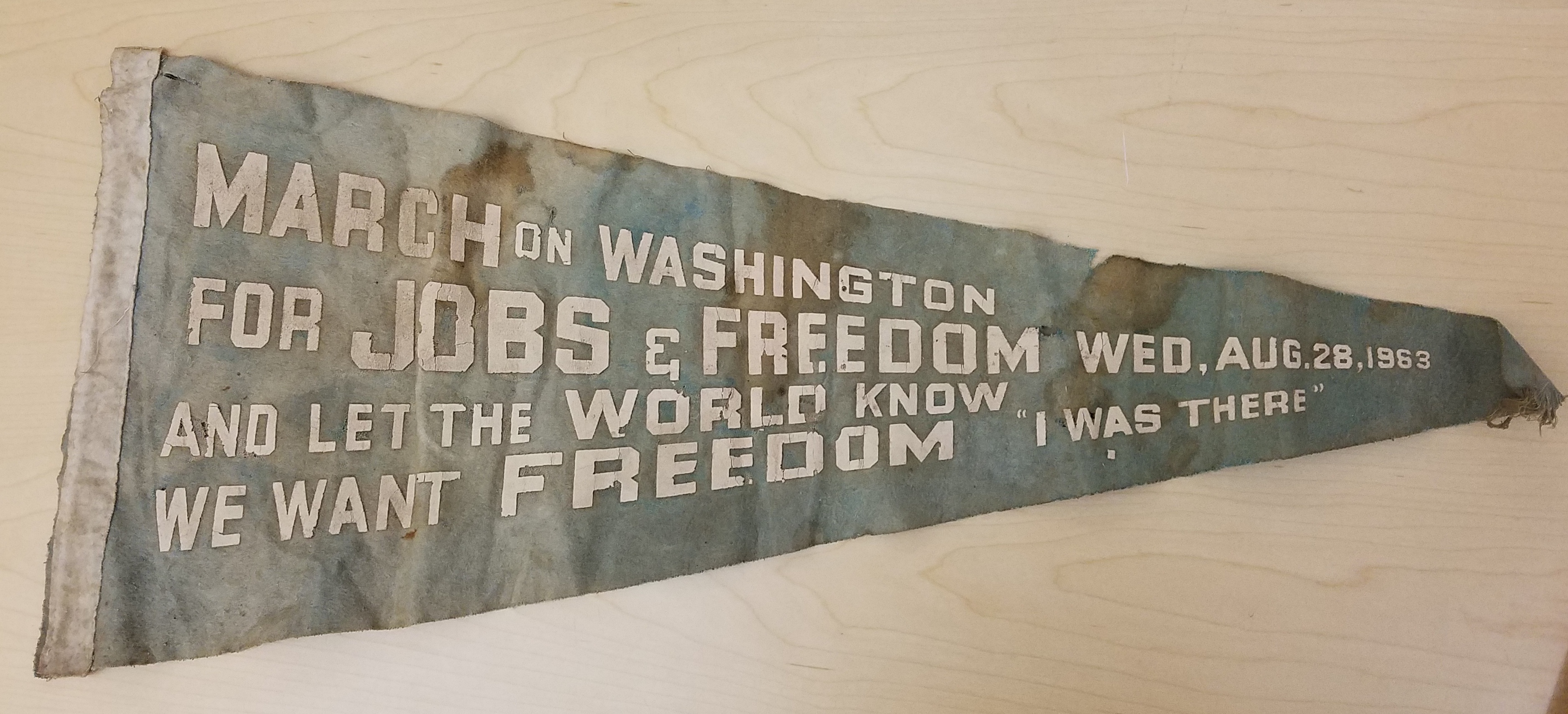 Faded and worn cloth pennant with the words March on Washington for Jobs and Freedom and Let the World Know We Want Freedom