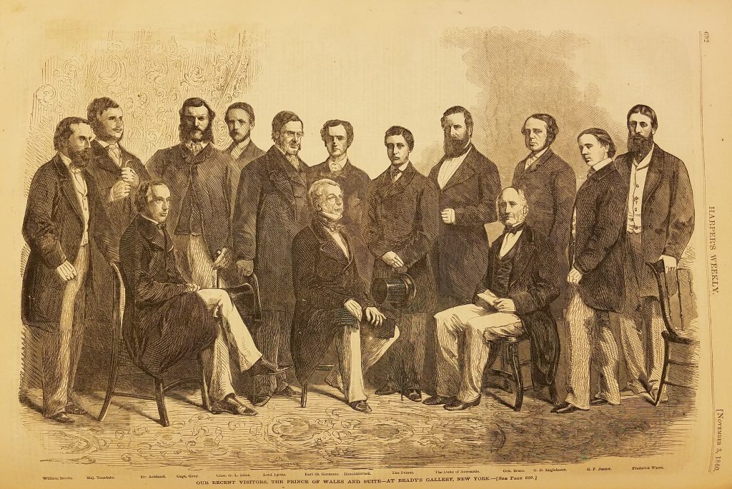 Wood engraving of 14 men dressed in 19th century suits with long jackets. Three are seated in chairs, the others standing. The image is captioned "The Prince of Wales and Suite"