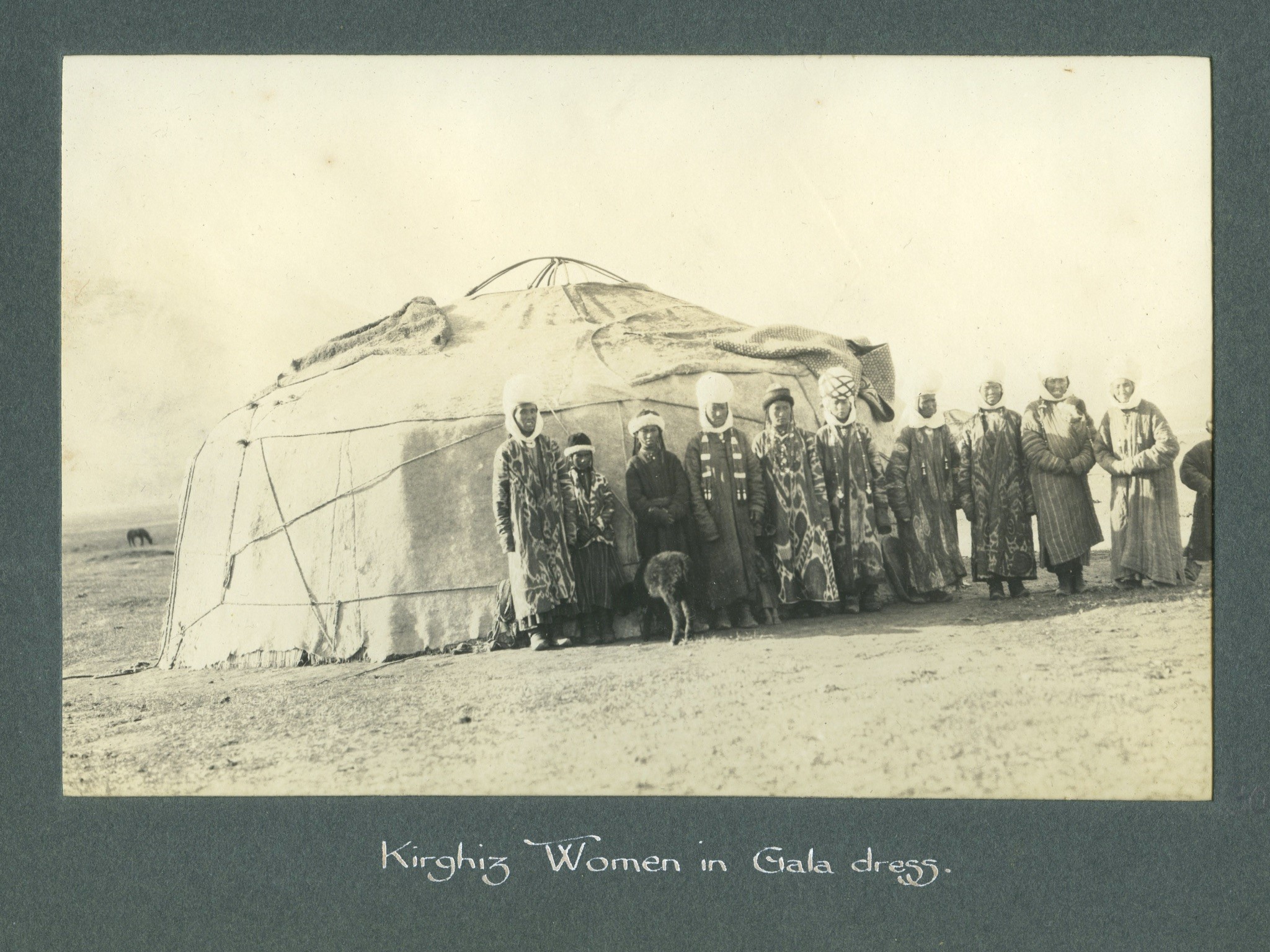 Kirghiz women standing together in front of a yurt.