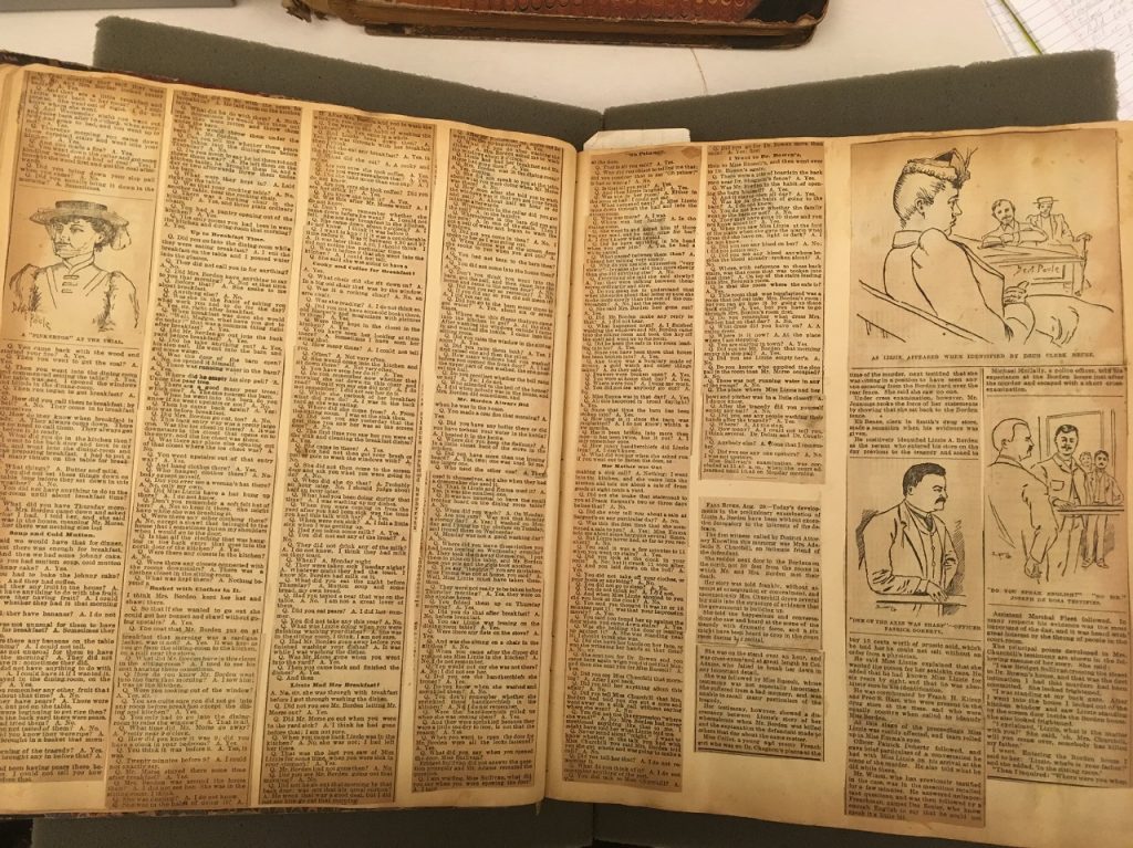 Photograph of opened scrapbook. Clippings from newspapers have been pasted in. The text is very small and the newspaper browning at the edges. 