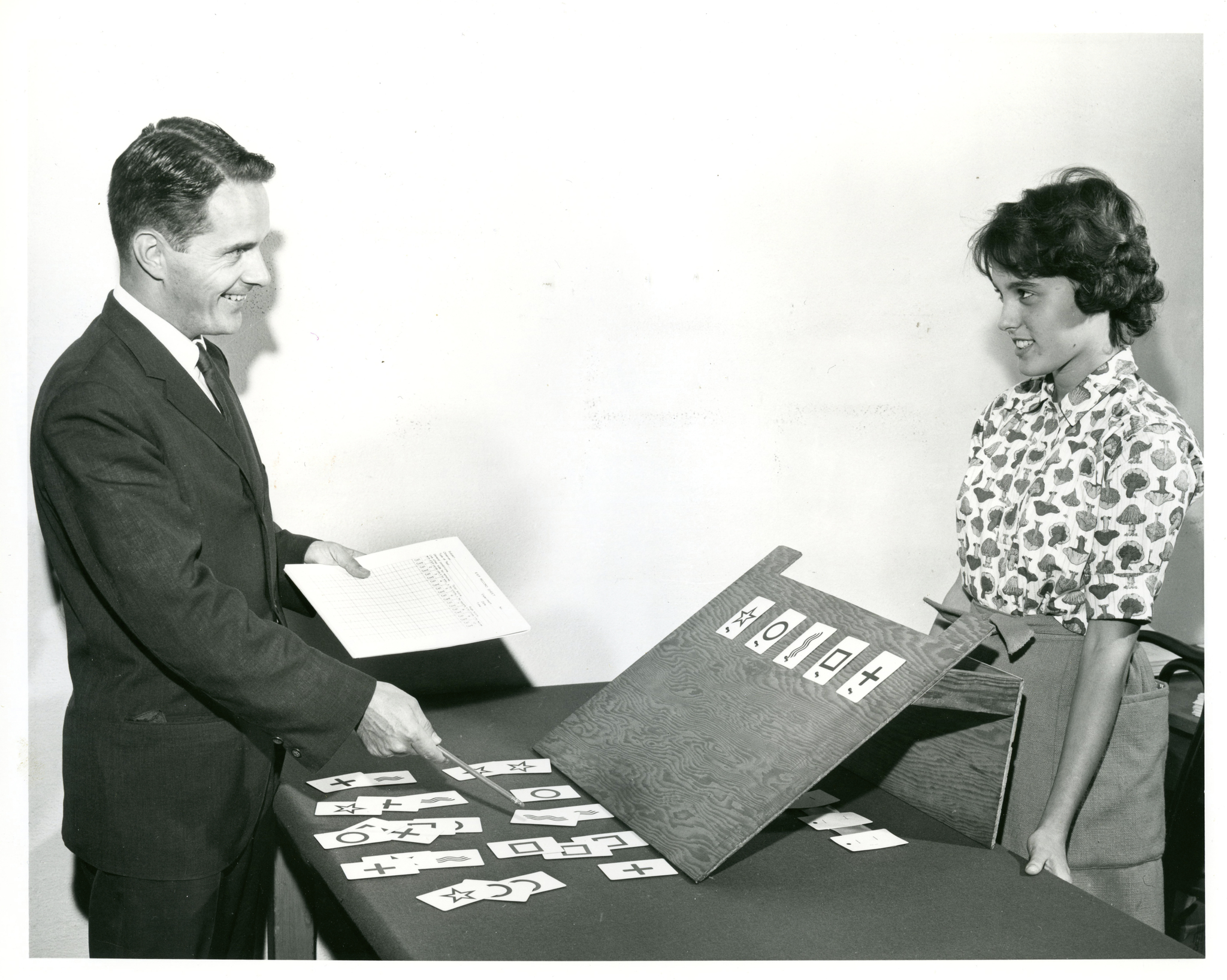 Man and woman stand around Zener Card display