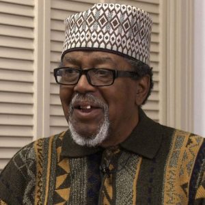 image of Worth Long with hat, glasses, goatee, and African print shirt