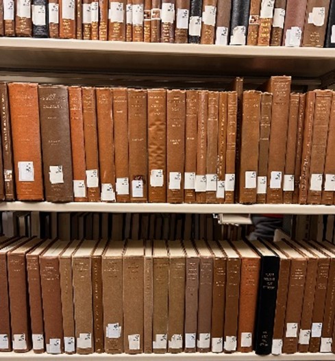 Shelves of orange-brown book spines with white library spine labels.