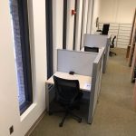 Two individual carrels with privacy walls next to a series of windows