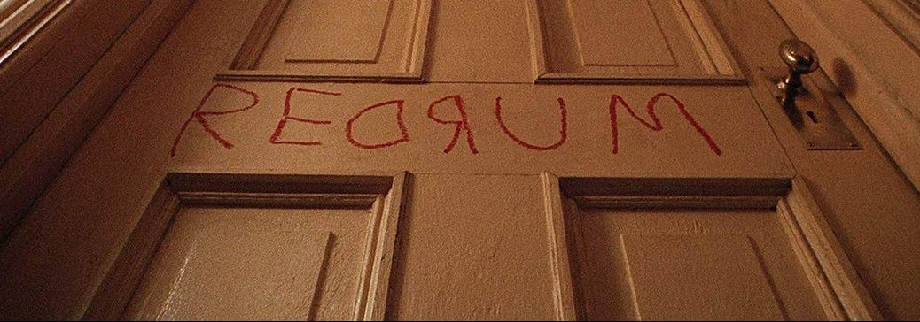 Close-up on door that has "Redrum" scratched into it; from movie, The Shining