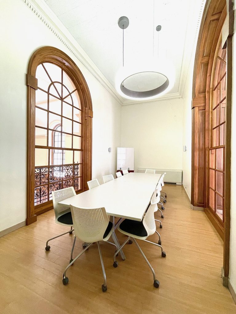 Photograph of balcony study area in Wall Center with large table, chairs, and a whiteboard