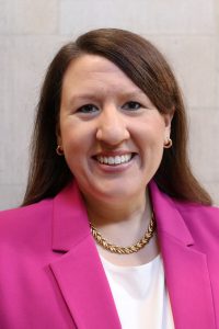 Woman wearing pink jacket and smiling